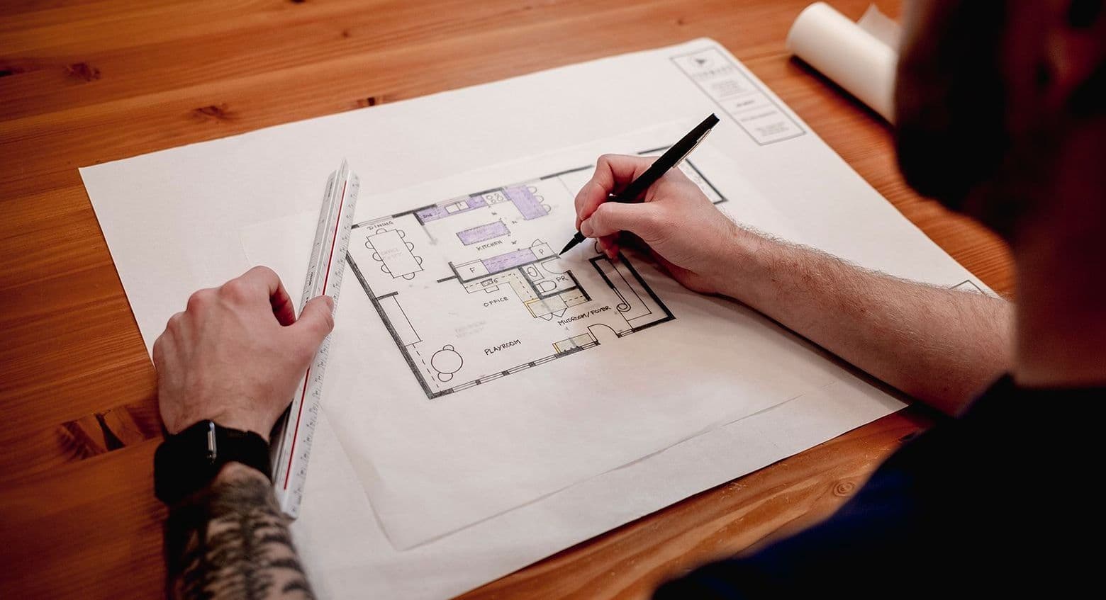 A person works on a blueprint.